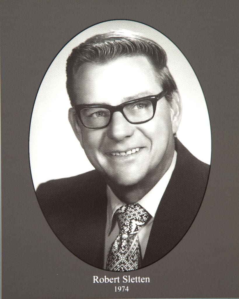 Black-and-white portrait of a man with glasses inside an oval frame, captioned 'Robert Sletten, 1974'