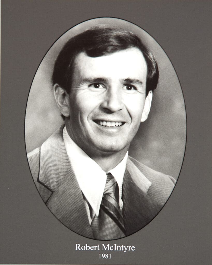 Smiling man in a suit photographed in black and white, framed oval with caption'Robert McIntyre 1981' below