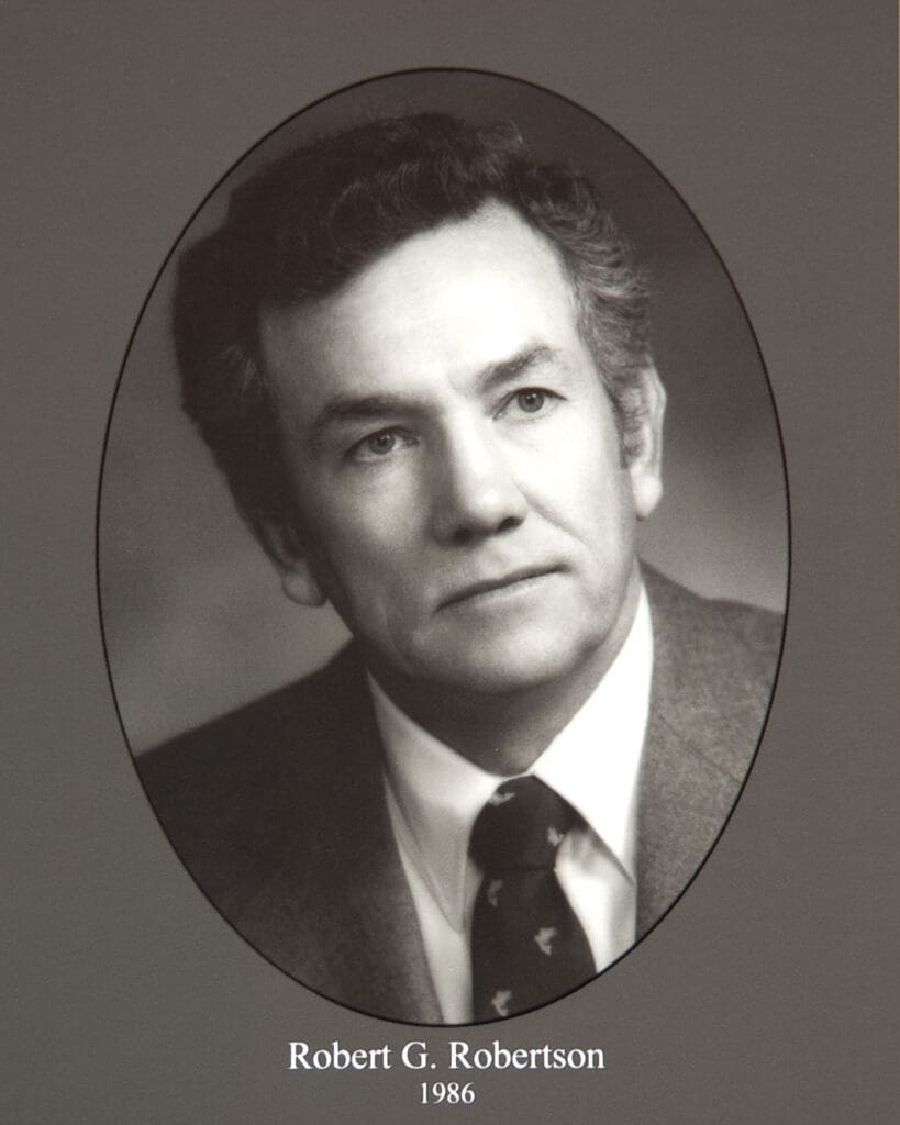Oval-framed black-and-white portrait of a man in a suit; caption reads'Robert G. Robertson 1986' at the bottom.