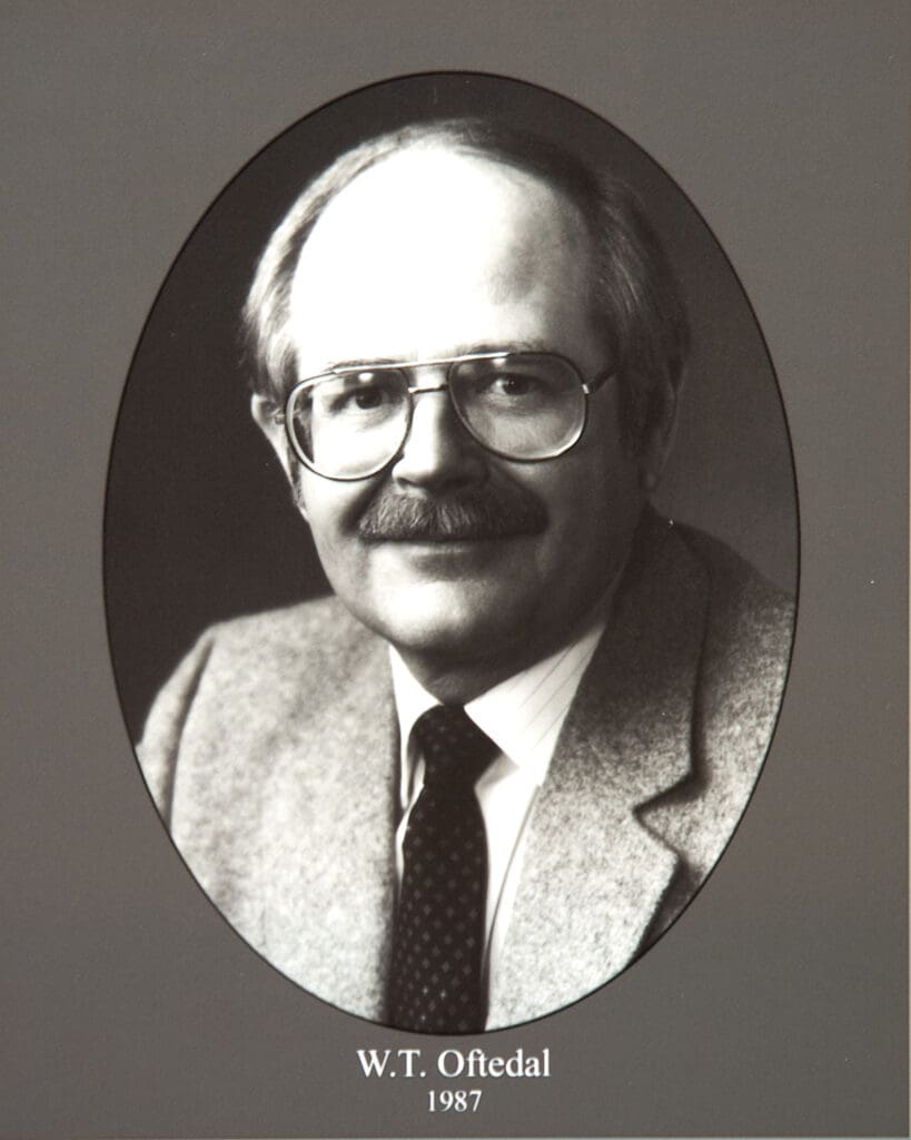 Black-and-white oval portrait of a man with glasses and a mustache in a suit; caption reads 'W.T. Oftedal 1987' below.