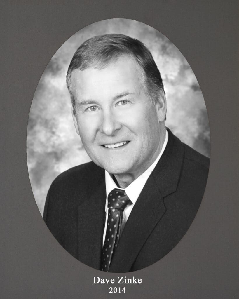 Black-and-white head-and-shoulders portrait of Dave Zinke in a suit, with the caption 'Dave Zinke 2014' beneath.