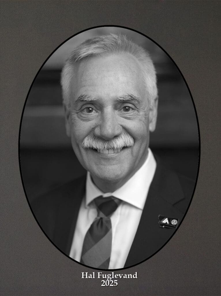 Formal black-and-white oval portrait of Hal Fugleland, smiling, in a suit and tie; labeled 'Hal Fugleland 2025' below.